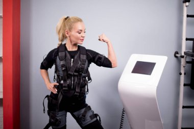 Genç harika kız spor yaptıktan sonra kaslı kollarını gösteriyor.