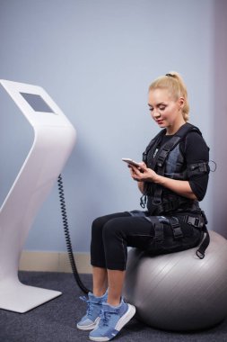 Güzel genç bayan spor merkezinde müzik indiriyor.