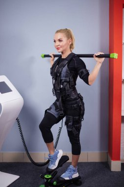 Beyaz elbiseli güzel kadın stepper 'da çalışıyor.