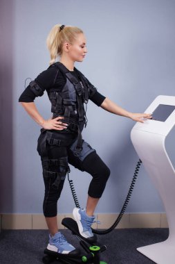 EM tabletinin yanındaki merdivende duran kendine güvenen sarışın sporcu kadın.