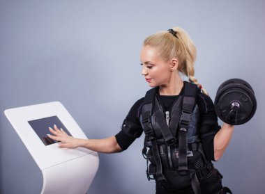 Sağlıklı genç bir kadının sağlık makinesini kontrol ederken çekilmiş yan görüntüsü.