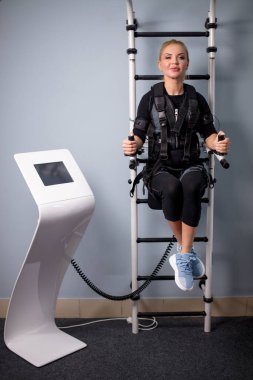 Paralel barlarda takım elbise giyen uygun bir kadın.