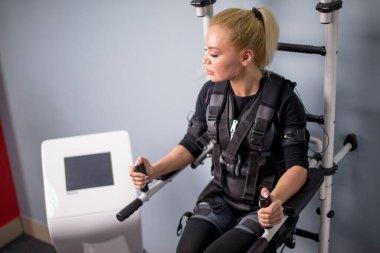 Yorgun, yorgun ve terli kız barlarda egzersiz yapmaya çalışıyor.