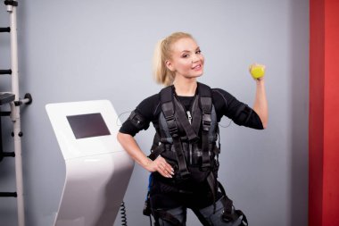 Elektrik kas uyarma makinesinde sarı halterli kız..