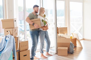 Taşınırken yeni eve karton kutular taşıyan mutlu çift.
