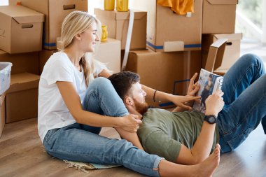 Kitaplı çift yeni eve taşınırken yatakta oturuyor.