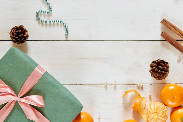 圣诞背景，白色木制桌子上有装饰品和绿色礼品盒 — 图库照片