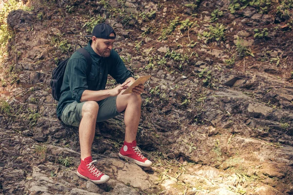 Turista s batohem procházky v horském lese, lezení na útes — Stock fotografie