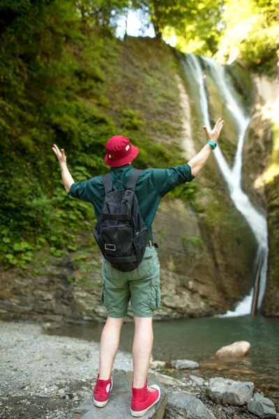 Foto trasera del viajero masculino con las manos levantadas antes de la cascada en Islandia — Foto de Stock