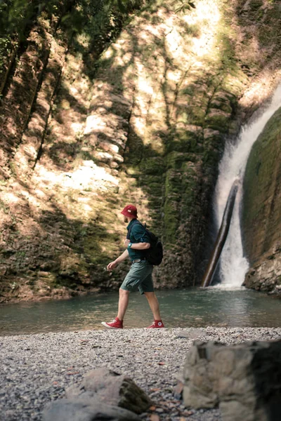 Jeune camping touristique avec sac à dos près d'une cascade en forêt. — Photo