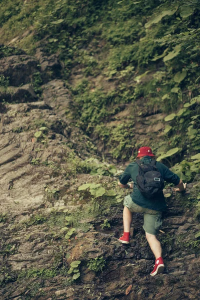 Turista s batohem procházky v horském lese, lezení na útes — Stock fotografie