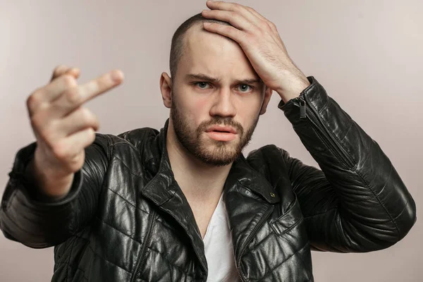 Hombre en elegante chaqueta de cuero que muestra aversión —  Fotos de Stock