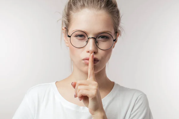 Giovane donna caucasica tenendo il dito alle labbra chiamando per mantenere il silenzio. — Foto Stock
