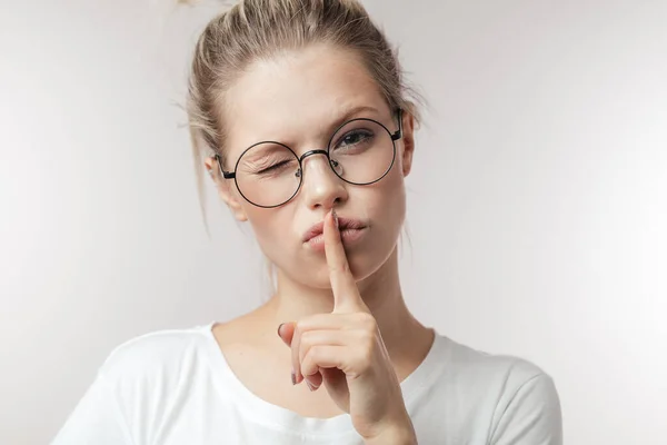 Vinger op de lippen - stil gebaar, vrouw houdt haar vinger aan haar lippen in een gebaar van stilte. — Stockfoto