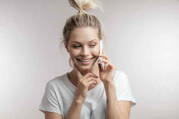 Beautiful smiling blond woman talking by cell mobile phone. Closeup. Isolated. — Stock Photo, Image