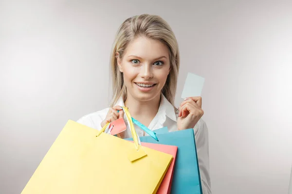 Fiatal boldog szőke nő, különböző színű bevásárlószatyrokkal — Stock Fotó