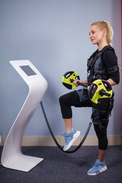 Pleasant blonde wearing EMS costume working out with barbell — Stock Photo, Image