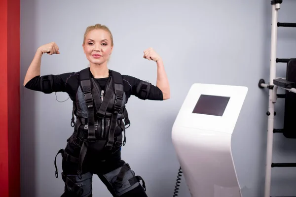 Joyeuse jeune fille aux cheveux blonds démontre ses bras forts — Photo