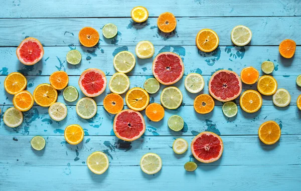 Cítricos naranja, limón, pomelo, mandarina, lima sobre fondo azul — Foto de Stock