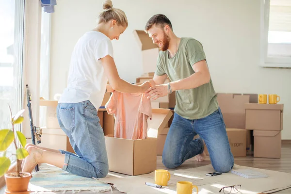 Koppel in nieuw appartement uitpakken kartonnen dozen — Stockfoto