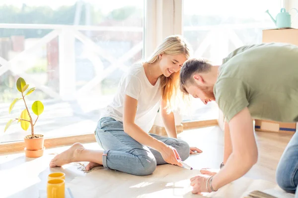 Pareja buscando planos de su nueva casa. Planificación del diseño de interiores — Foto de Stock