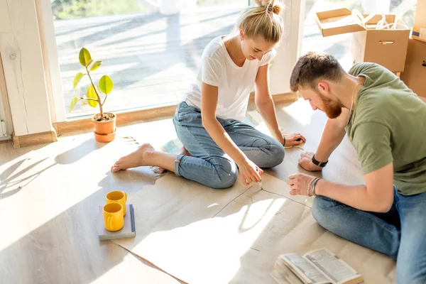 Casal procurando plantas de sua nova casa. Planejamento de interiores — Fotografia de Stock