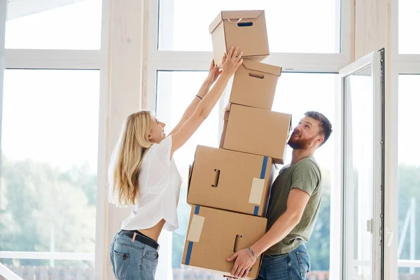 Hembra colocación de cajas móviles en gran pila hombre está sosteniendo todos — Foto de Stock