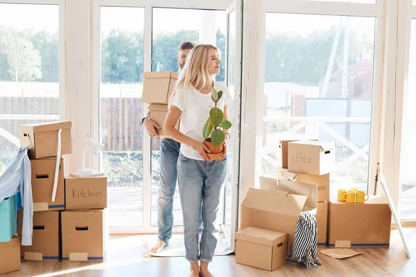 Pareja feliz llevando cajas de cartón en un nuevo hogar en el día de mudanza — Foto de Stock