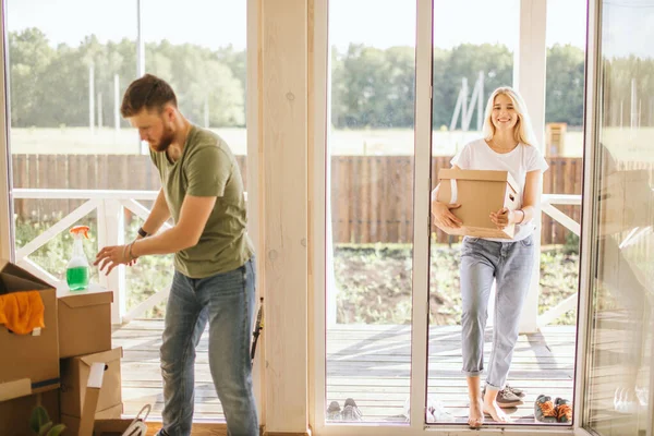 Glada par bär kartonger till nya hem på flyttdagen — Stockfoto