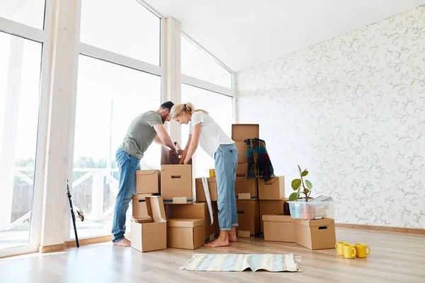 Casal em novo apartamento desembalar caixas de papelão — Fotografia de Stock