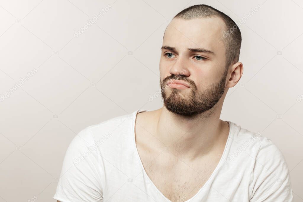 upset, unhappy young man looking aside