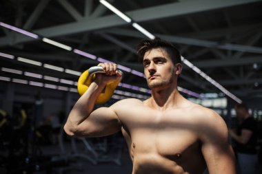 Genç fitness adamı Kettlebell 'de antrenman yapıyor..