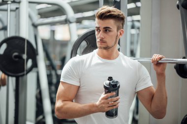 Spor salonundaki antrenman sırasında dinlenen yakışıklı adam.