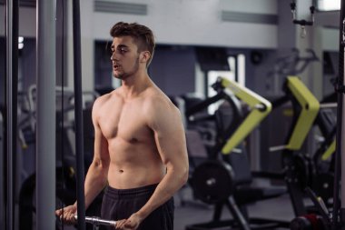 Vücut geliştirici beden eğitimi öğretmeniyle egzersiz yapıyor.