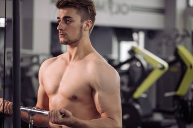 Vücut geliştirici beden eğitimi öğretmeniyle egzersiz yapıyor.