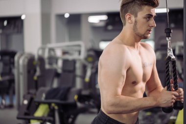 Vücut geliştirici beden eğitimi öğretmeniyle egzersiz yapıyor.