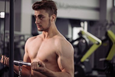 Vücut geliştirici beden eğitimi öğretmeniyle egzersiz yapıyor.