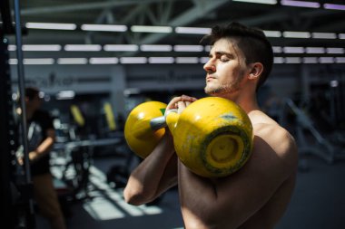 Genç fitness adamı Kettlebell 'de antrenman yapıyor..