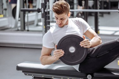 Modern spor salonunda karın kası egzersizi yapan kaslı adam. Spor salonunda mekik çeken zinde bir adam..