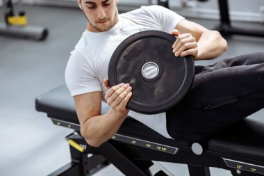 Modern spor salonunda karın kası egzersizi yapan kaslı adam. Spor salonunda mekik çeken zinde bir adam..