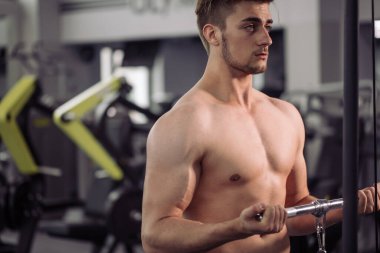 Vücut geliştirici beden eğitimi öğretmeniyle egzersiz yapıyor.