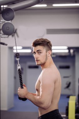 Vücut geliştirici beden eğitimi öğretmeniyle egzersiz yapıyor.