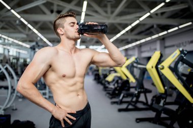 Spor salonundaki antrenman sırasında dinlenen yakışıklı adam.