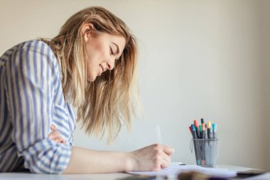 Kadınlar yazı yazarlar, işaret fırçası kullanarak kağıt üzerinde sanat yaparlar.