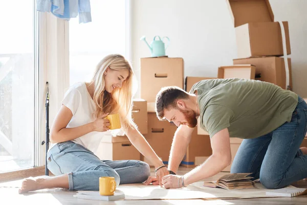 Pareja buscando planos de su nueva casa. Planificación del diseño de interiores — Foto de Stock