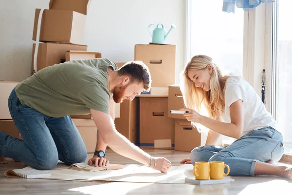 Casal procurando plantas de sua nova casa. Planejamento de interiores — Fotografia de Stock