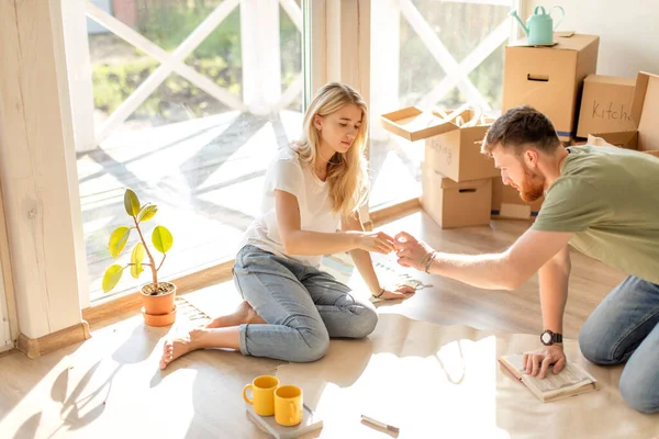 Pareja buscando planos de su nueva casa. Planificación del diseño de interiores — Foto de Stock