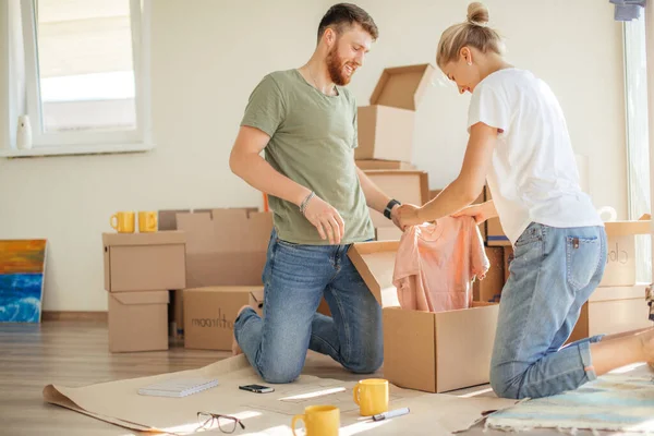 Pareja en apartamento nuevo desembalaje cajas de cartón —  Fotos de Stock