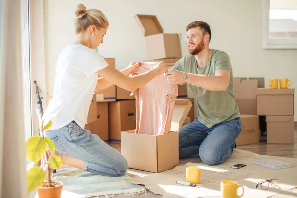 Pareja en apartamento nuevo desembalaje cajas de cartón —  Fotos de Stock