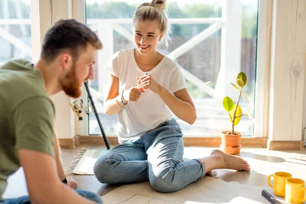 Pareja buscando planos de su nueva casa. Planificación del diseño de interiores — Foto de Stock